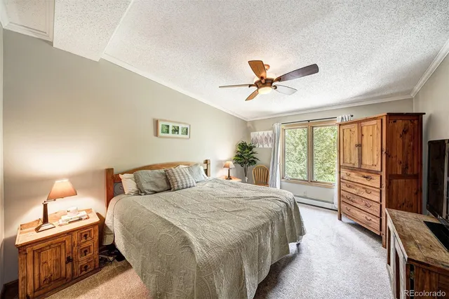 a bedroom with a bed and a refrigerator