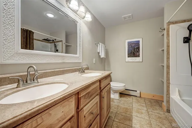 a bathroom with a granite countertop sink a toilet and a mirror
