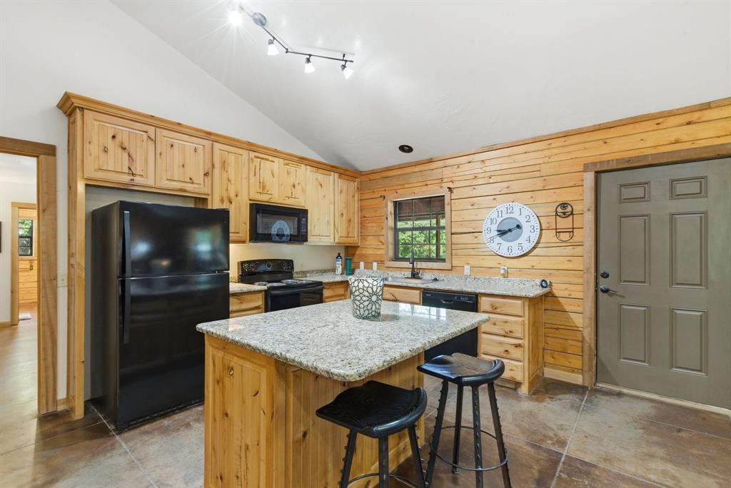 2197 Netherly Lane Forestburg, TX 76239 - Photo 21 of 40 a kitchen with stainless steel appliances kitchen island granite countertop a refrigerator a stove top oven and a dining table