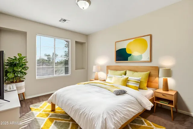 a bedroom with a large bed and a potted plant