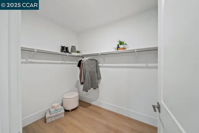 a view of walk in closet with clothes and shoes