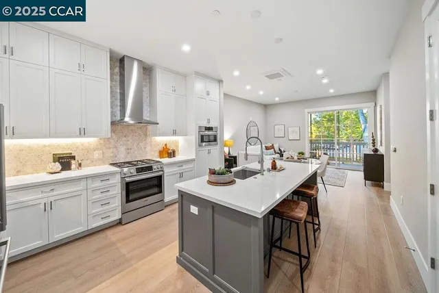 a kitchen with a stove a sink a kitchen island with a dining table and chairs