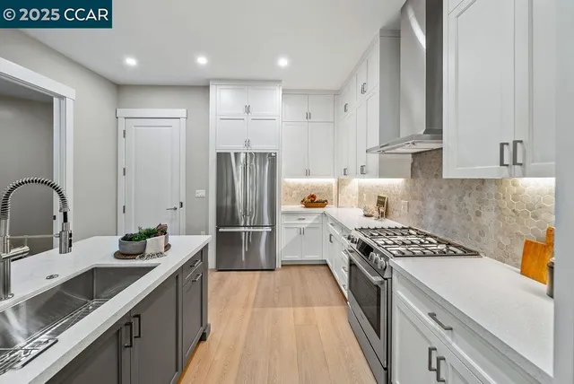 a kitchen with a sink a refrigerator and cabinets