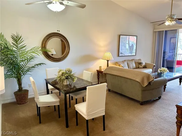 a living room with furniture a window and a potted plant