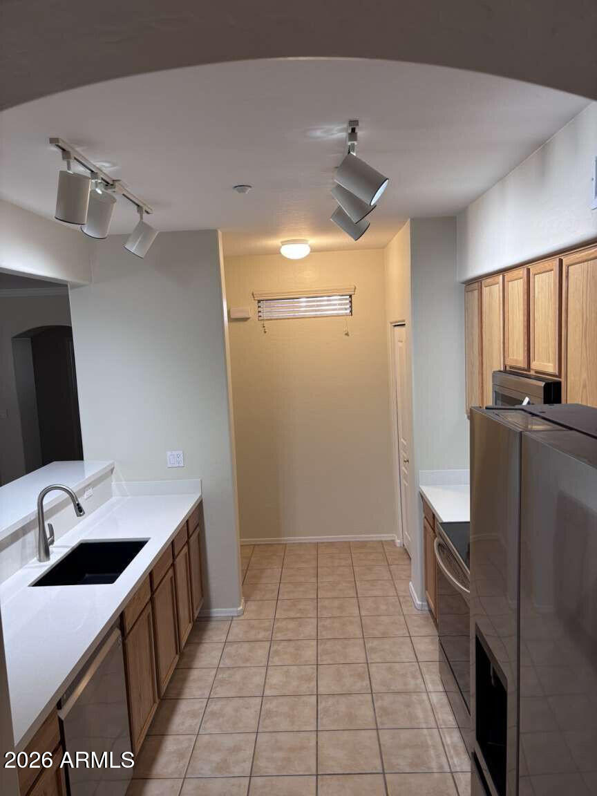 955 East Knox Road, Unit 118 Chandler, AZ 85225 - Photo 17 of 50 a kitchen with a sink a counter top space stainless steel appliances and a window