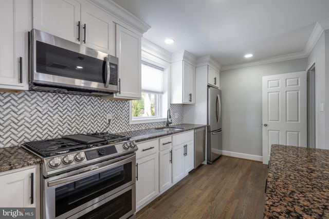 a kitchen with stainless steel appliances kitchen island granite countertop a stove a sink and a microwave