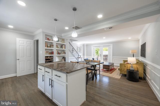 a open kitchen with stainless steel appliances granite countertop a lot of cabinets and wooden floor