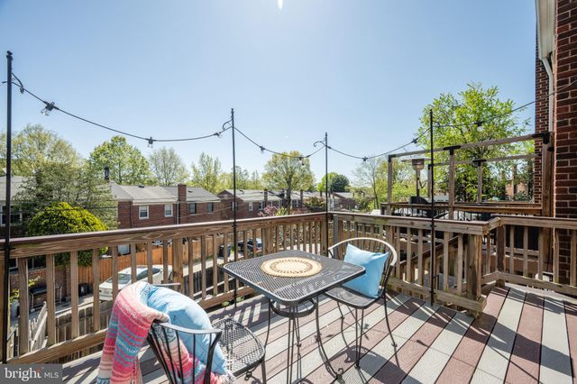 a balcony with wooden floor table and chairs