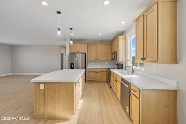 a kitchen with stainless steel appliances granite countertop a sink a stove and a refrigerator