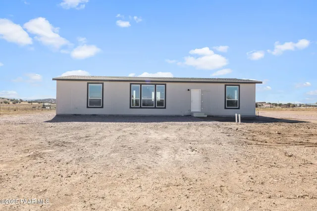 a view of house with backyard and wooden fence