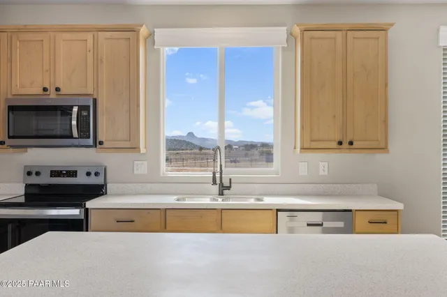 a kitchen with stainless steel appliances granite countertop a sink a stove and a microwave