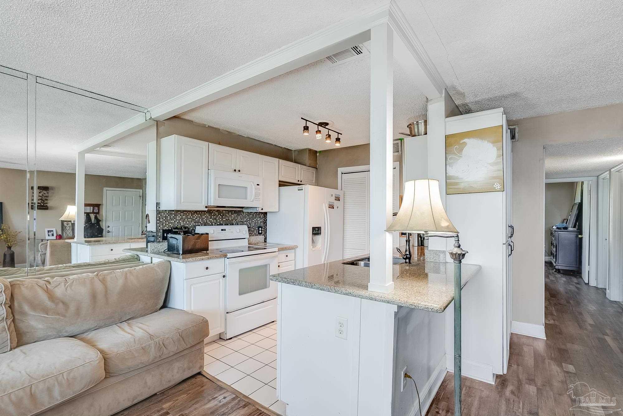 200 Pensacola Beach Road, Unit D2 Gulf Breeze, FL 32561 - Photo 14 of 40 a living room with stainless steel appliances furniture a rug and a view of kitchen