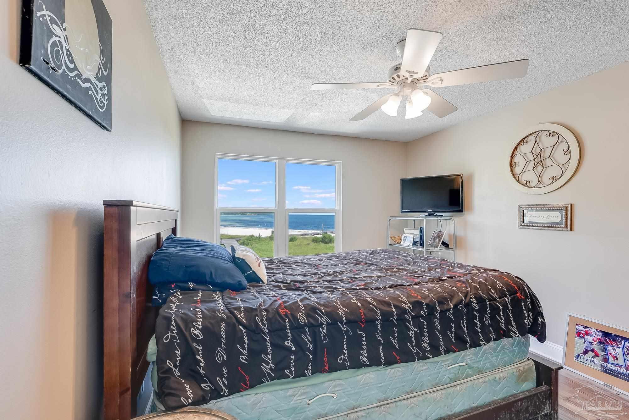 200 Pensacola Beach Road, Unit D2 Gulf Breeze, FL 32561 - Photo 20 of 40 a bedroom with a bed and a chandelier
