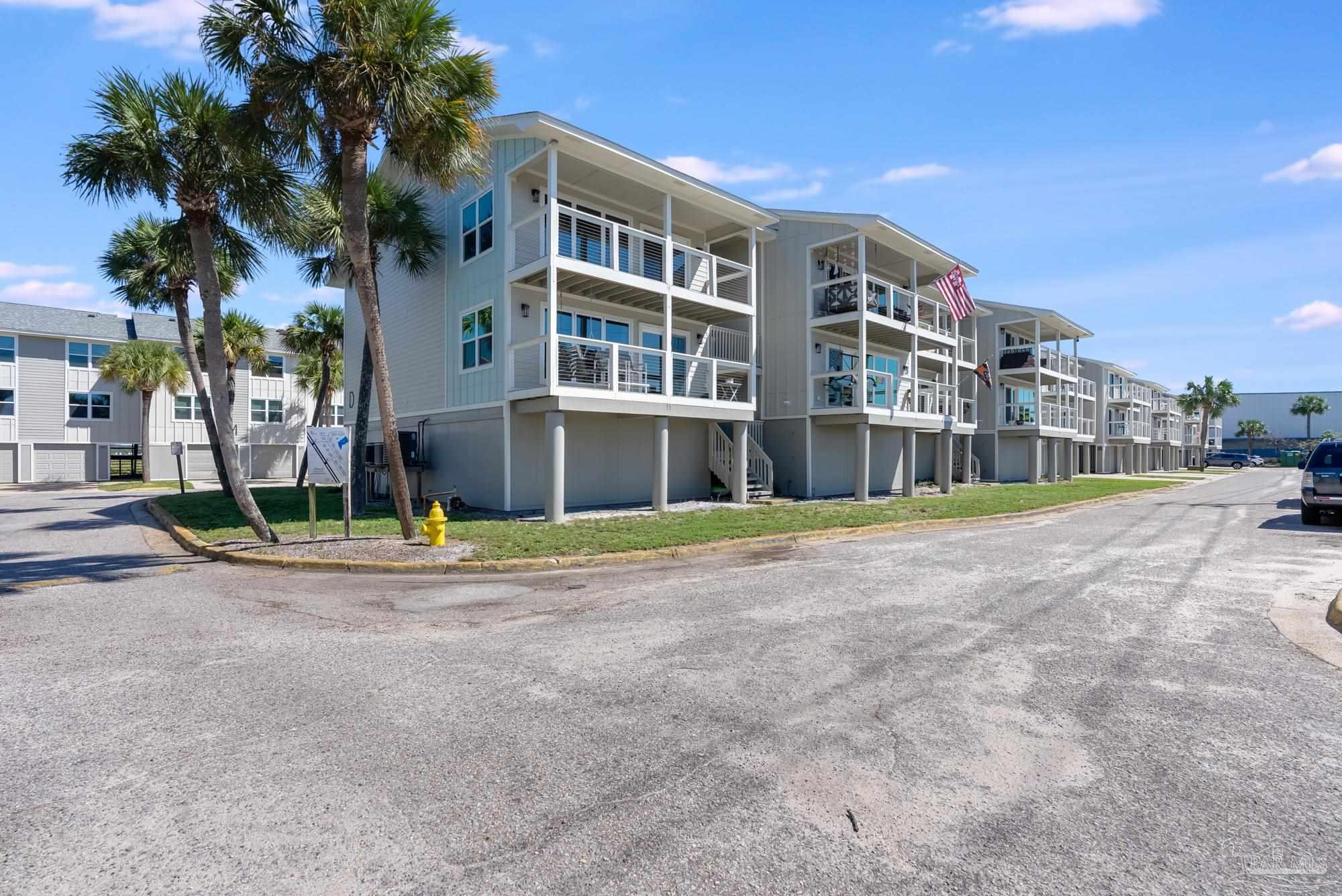 200 Pensacola Beach Road, Unit D2 Gulf Breeze, FL 32561 - Photo 37 of 40 a front view of a building with a yard and palm trees