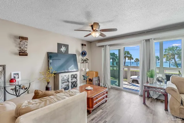 a living room with furniture a flat screen tv and a large window