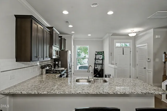 a kitchen with stainless steel appliances granite countertop a refrigerator stove and sink