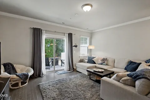 a view of a dining room with furniture a rug and wooden floor