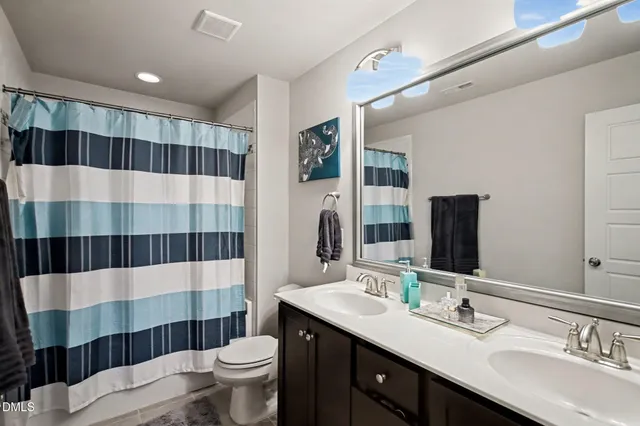 a bedroom with a bed and dresser with mirror