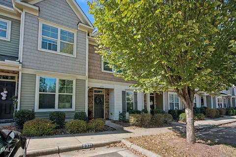 front view of a brick house with potted plants