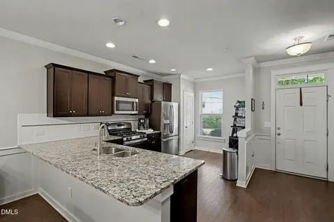 a kitchen with granite countertop a refrigerator and a sink
