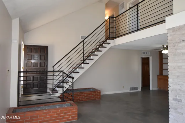 a kitchen with a sink a stove and a dining table with wooden cabinet