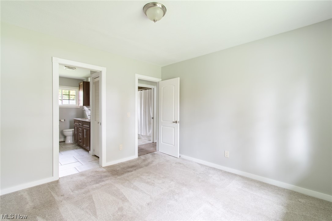 1565 Merle Road Salem, OH 44460 - Photo 8 of 13 Unfurnished bedroom featuring connected bathroom and light tile floors