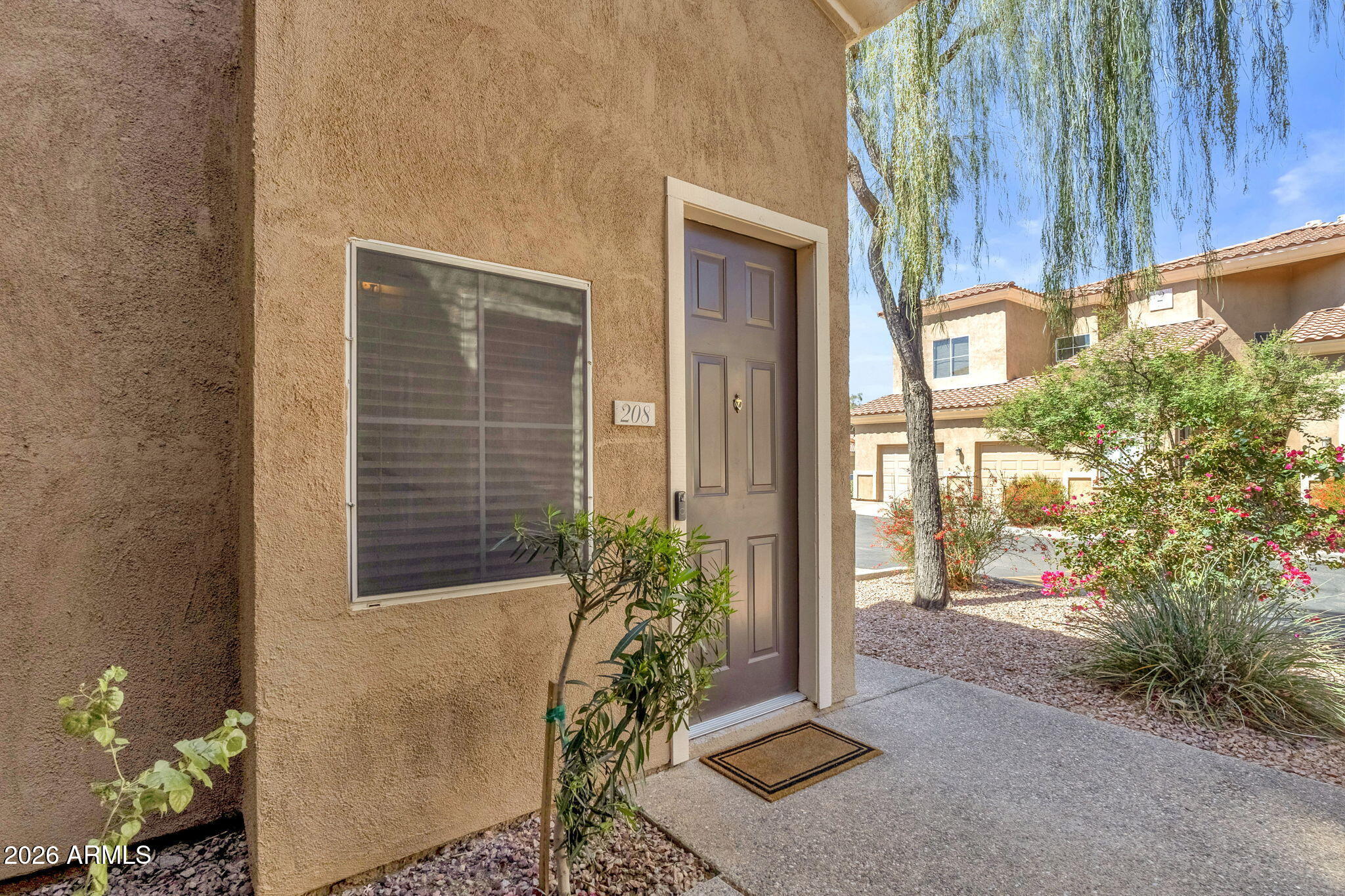 8245 East Bell Road, Unit 208 Scottsdale, AZ 85260 - Photo 13 of 48 a house with potted plants in front of door