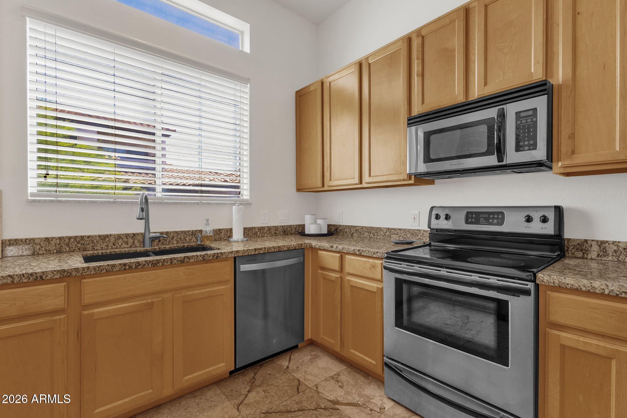 8245 East Bell Road, Unit 208 Scottsdale, AZ 85260 - Photo 27 of 48 a kitchen with granite countertop cabinets stainless steel appliances and a sink
