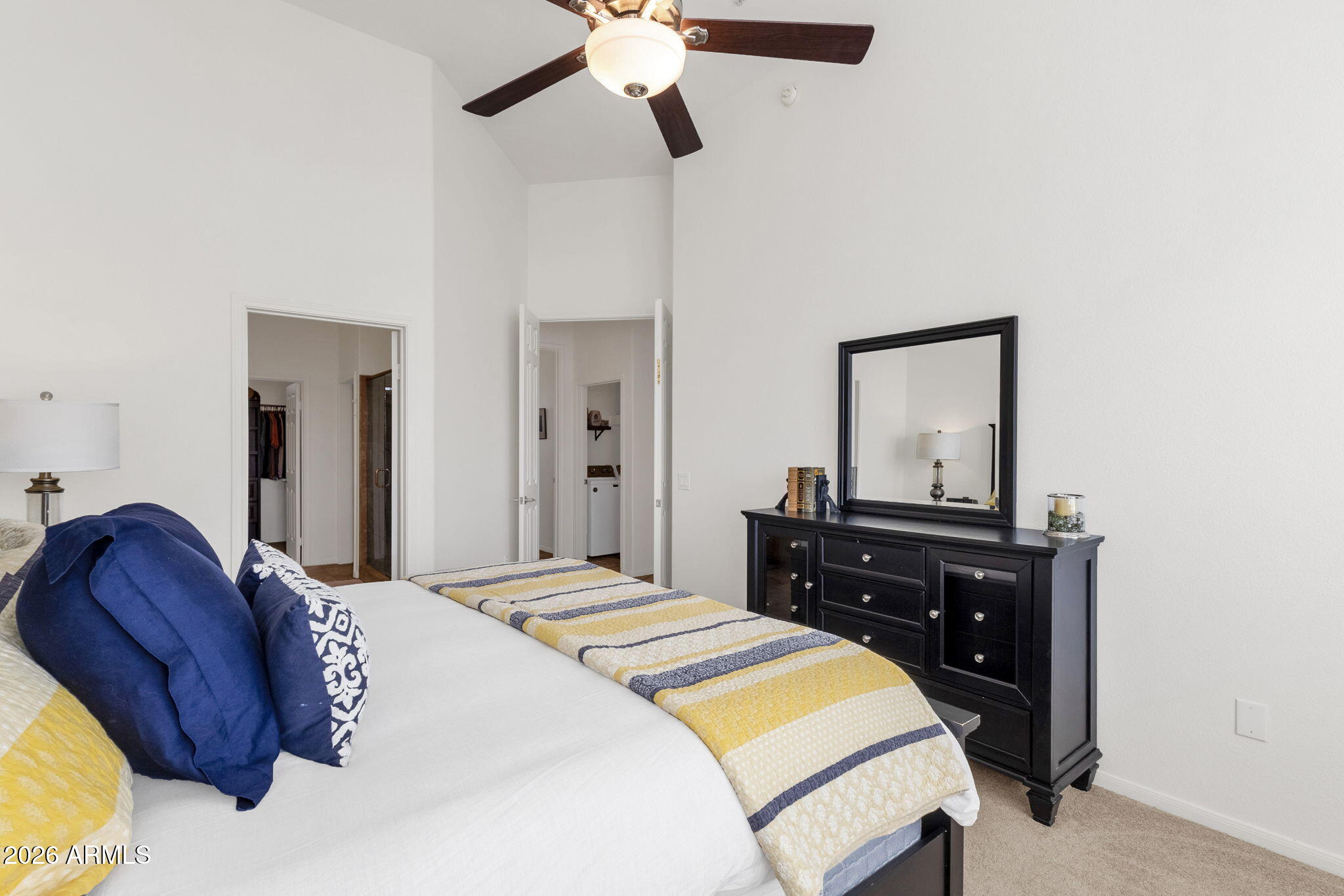 8245 East Bell Road, Unit 208 Scottsdale, AZ 85260 - Photo 31 of 48 a bedroom with a bed and dresser with mirror