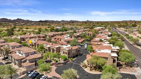 an aerial view of residential houses with outdoor space and trees