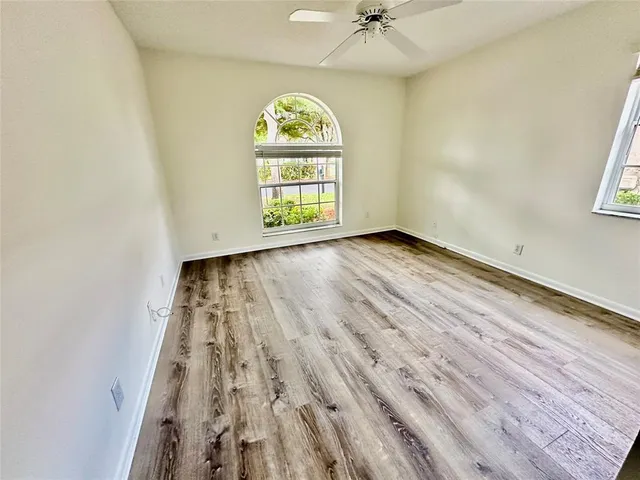 an empty room with a ceiling fan and a window