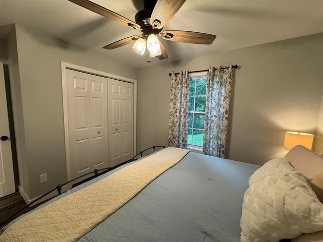 a bedroom with a large bed and a chandelier