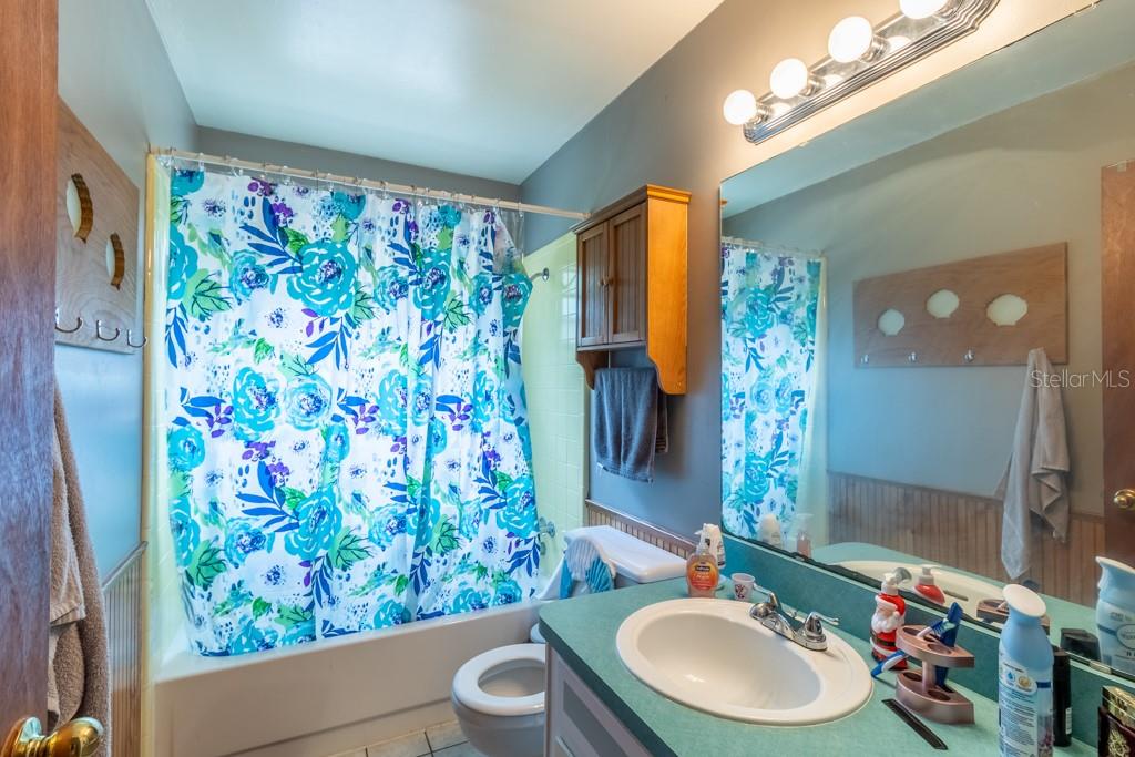 126 Southwest 40 Terrace Gainesville, FL 32607 - Photo 17 of 21 a bathroom with a sink a toilet a mirror a vanity and shower curtain