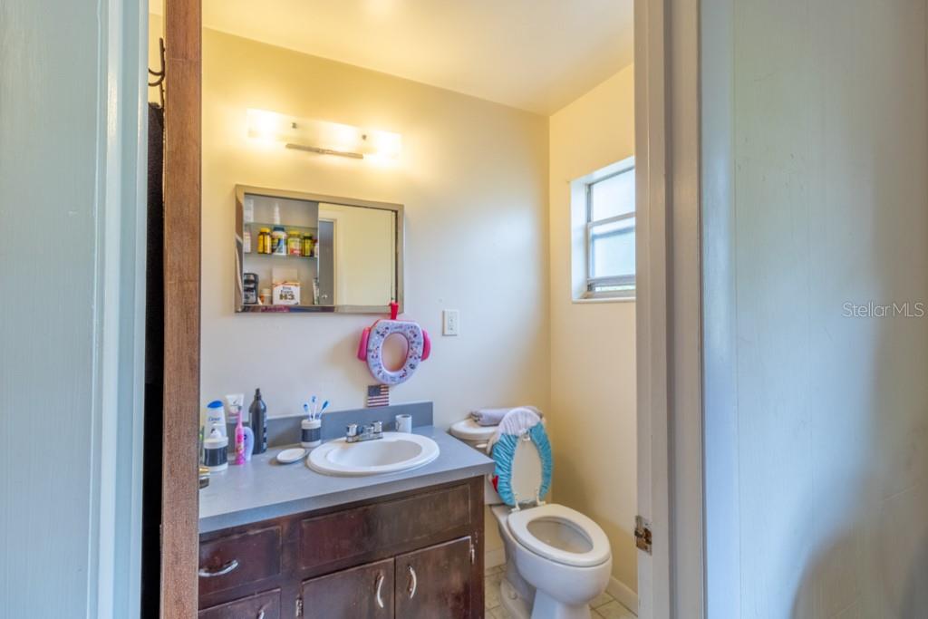 126 Southwest 40 Terrace Gainesville, FL 32607 - Photo 19 of 21 a bathroom with a granite countertop sink a toilet and a mirror