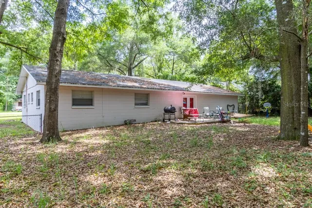 a backyard of a house with table and chairs