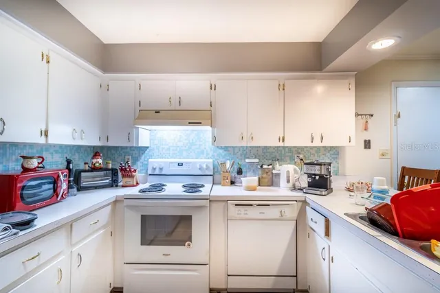 a kitchen with a white cabinets and white appliances