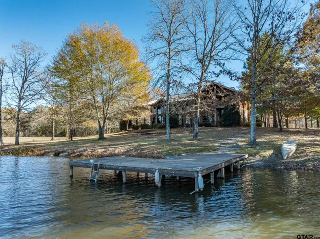a view of house with lake view and trees