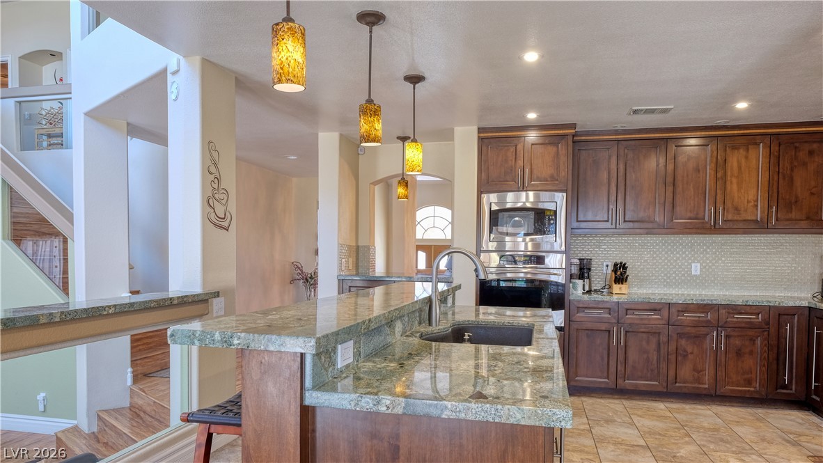 3704 North Campbell Road Las Vegas, NV 89129 - Photo 14 of 38 An inviting kitchen with rich cabinetry and polished granite counters for culinary creativity.