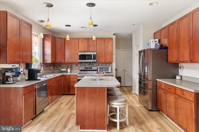 a kitchen with stainless steel appliances a stove refrigerator sink microwave and cabinets