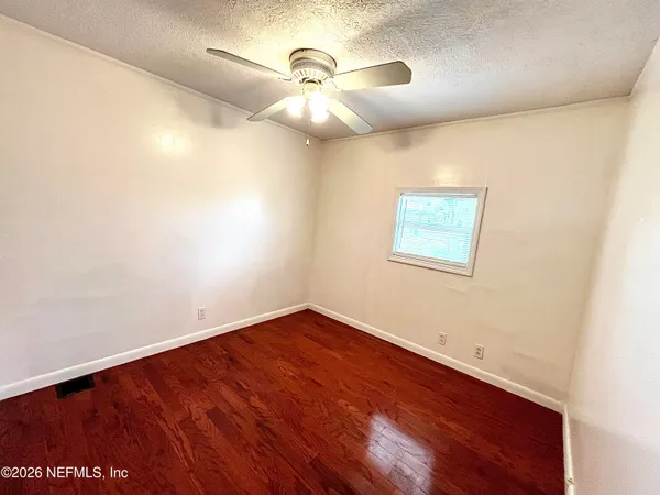 a view of empty room with wooden floor