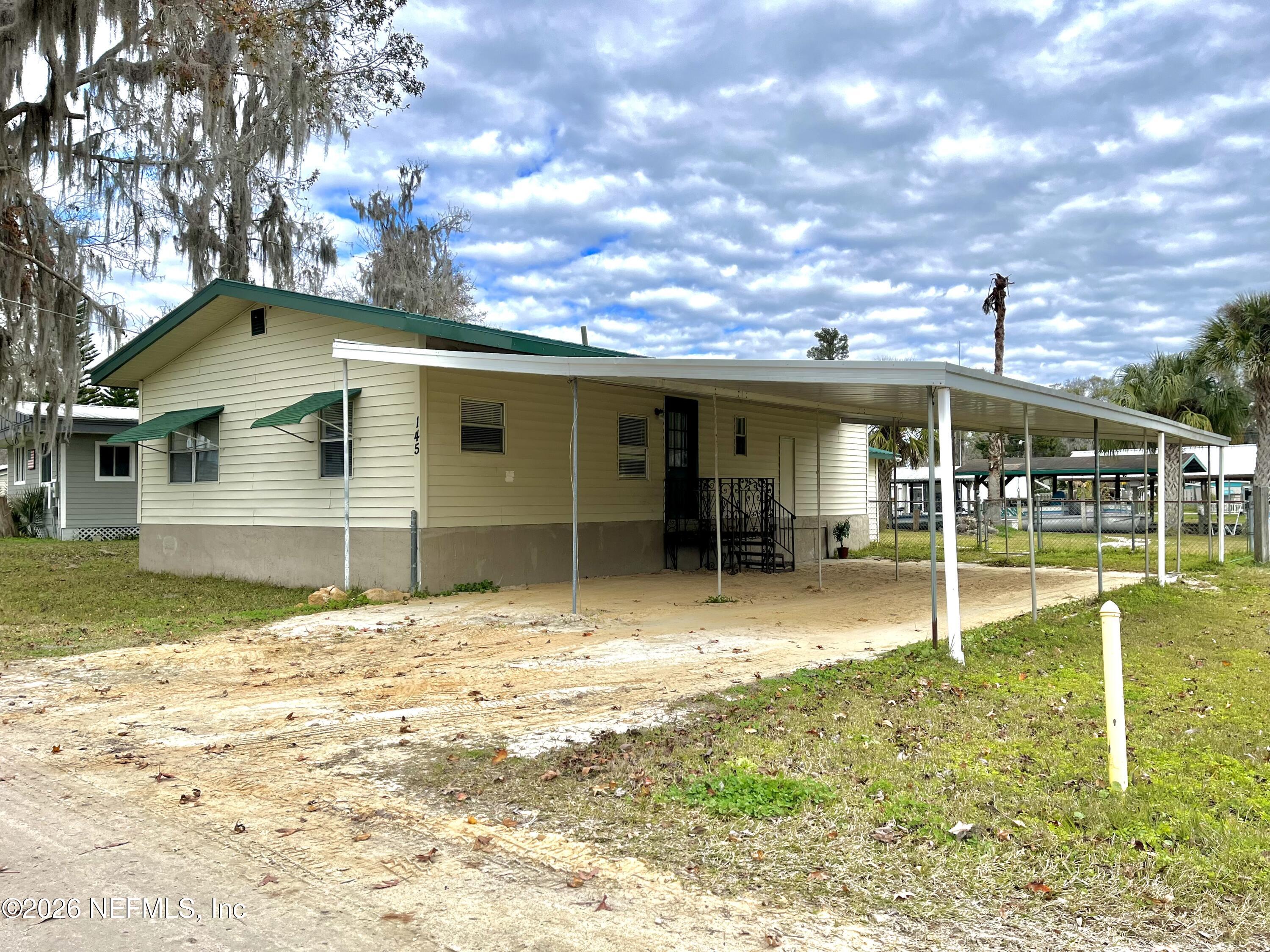145 Magnolia Trail Satsuma, FL 32189 - Photo 3 of 20 a backyard of a house with table and chairs