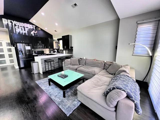 a living room with stainless steel appliances furniture and rug