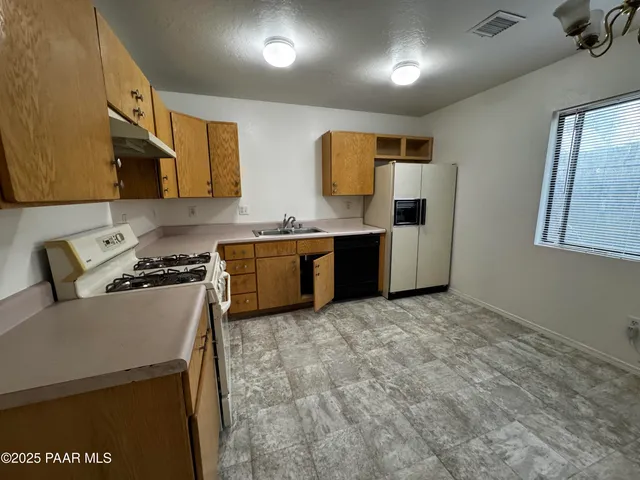 a kitchen with stainless steel appliances granite countertop a stove a sink a refrigerator and a microwave