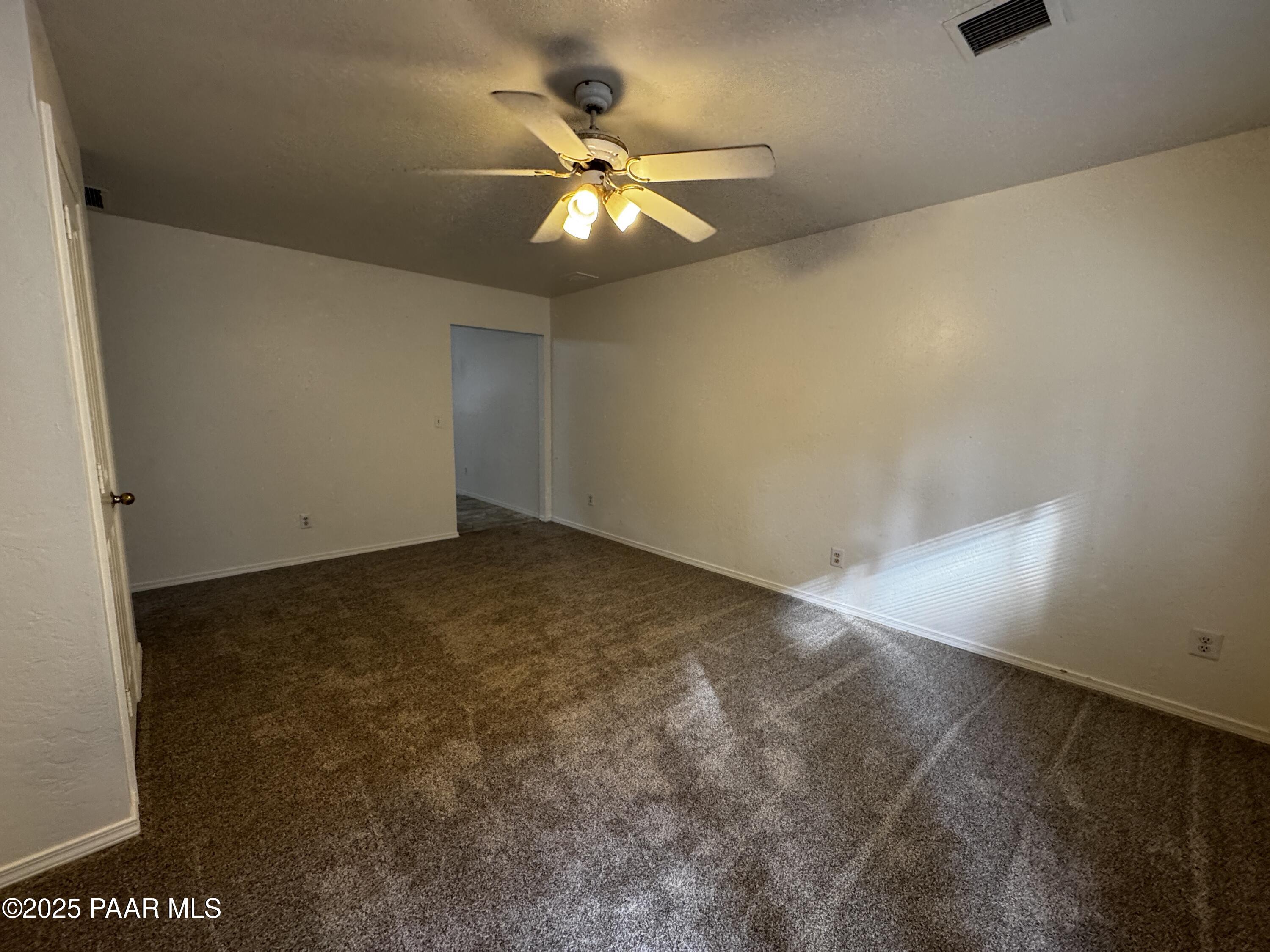 719 Bird Street, Unit B Prescott, AZ 86301 - Photo 8 of 12 an empty room with a chandelier fan and windows