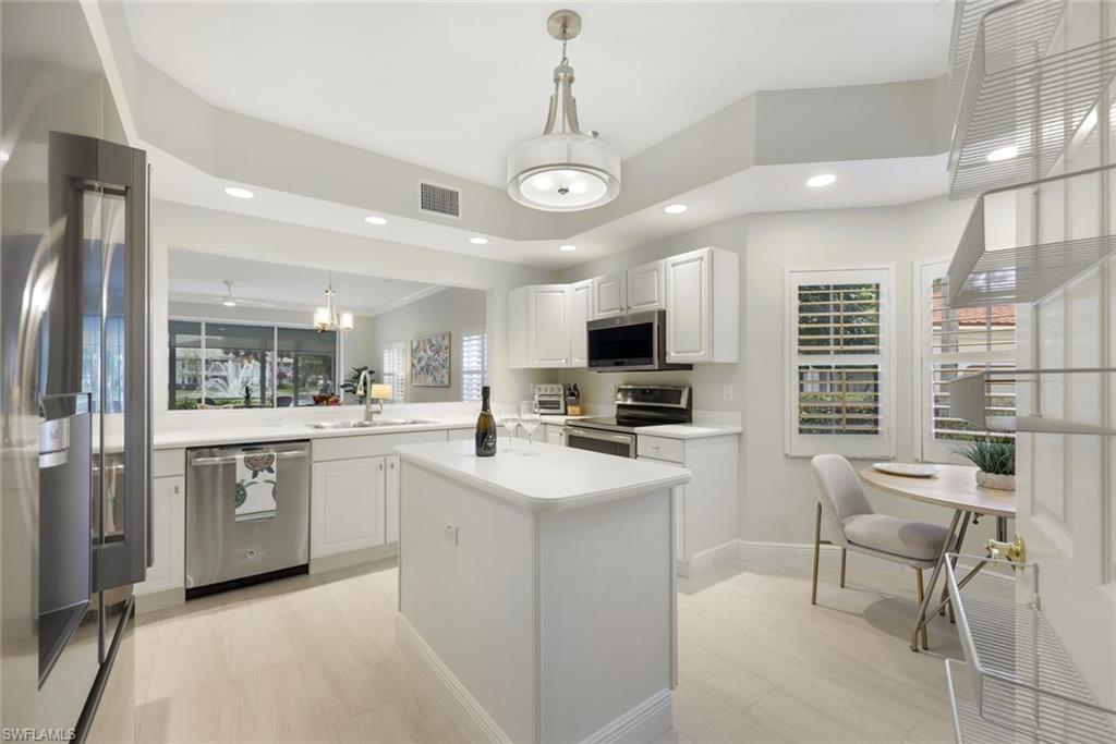 6240 Reserve Circle, Unit 802 Naples, FL 34119 - Photo 16 of 47 Newer kitchen appliances, kitchen sink, faucet, garbage disposal, and lighting.