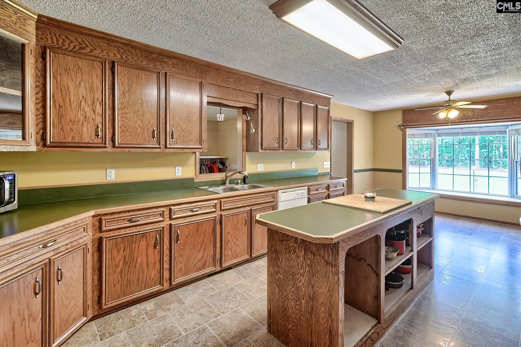 1415 State Rd S-28-55 Lugoff, SC 29078 - Photo 21 of 39 a kitchen with a sink stove and cabinets