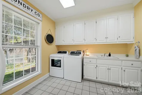 a kitchen with white cabinets and window