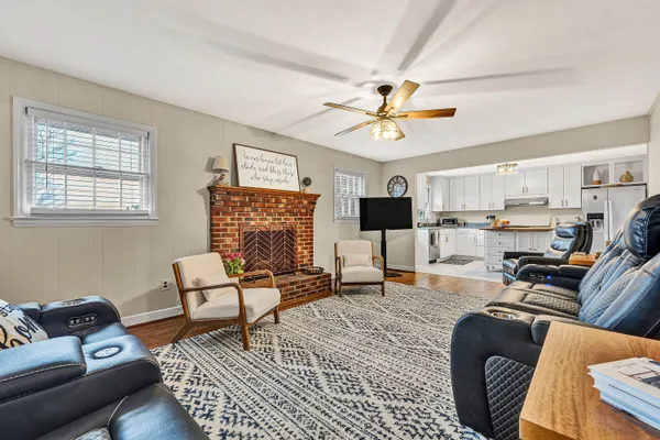 a living room with furniture ceiling fan and a window