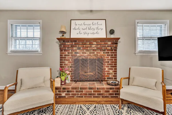 a living room with furniture a fireplace and a window