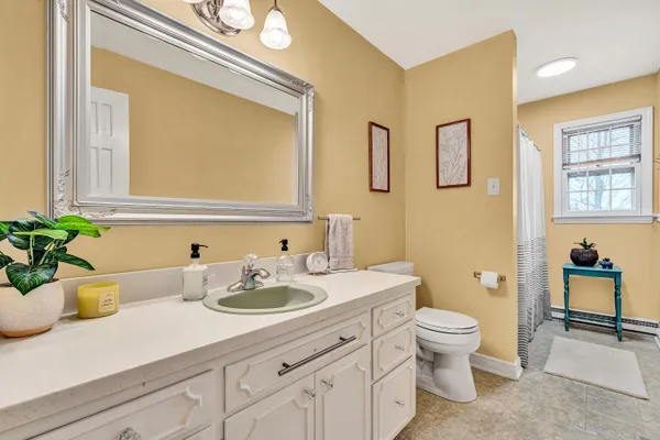 a bathroom with a granite countertop toilet sink and mirror